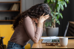 Photo of a woman sitting down with her elbows on a table holding her face in her hands. With stress and anxiety counseling in Atlanta, GA you can begin to manage your symptoms to live a stress free life.