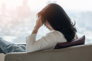 Photo of a woman sitting in a chair holding her hand on her head. Stress and anixety can be overwhelming. Learn how stress and anxiety counseling in Atlanta, GA can help you manage your symptoms to live a healthier lifestyle.