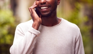 Photo of a African American male smiling while talking on his cell phone. This photo represents the freedom depression therapy in Atlanta, GA can bring you when you begin managing your depression symptoms.