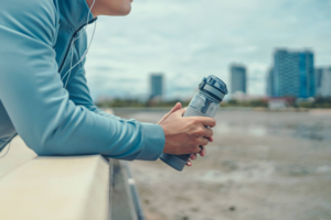 Photo of a man leaning over a railing using headphones and holding a waterbottle with a cityscape behind him. If your intrusive thoughts are causing you stress in your life, discover how anxiety therapy in Atlanta, GA can help you begin to overcome your symptoms.