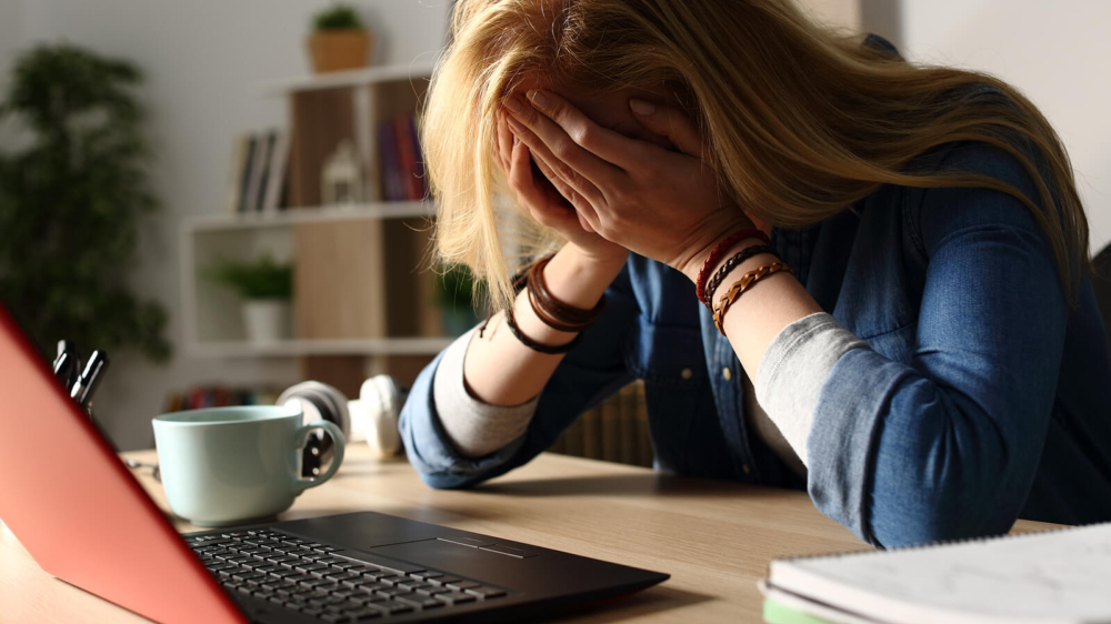 Photo of a stressed woman working from home. Are you unable to feel motivated and stress free while at work? Learn tips on being motivated and stress free while working from home and how stress therapy in Atlanta, GA can help you.