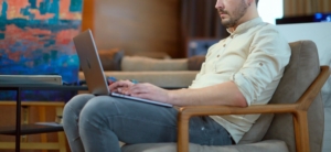 Photo of a man sitting in a chair using his laptop. By working with an anxiety therapist online you can start overcoming your symptoms. Learn to manage your anxiety with anxiety therapy in Atlanta, GA here.