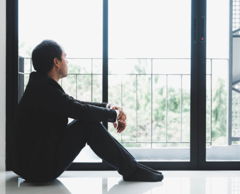 Photo of a man sitting on the floor looking out a window. Are you struggling with the symptoms of depression but not sure if you should seek therapy? Learn how depression therapy in Atlanta, GA can help you begin to manage your emotions and begin healing.