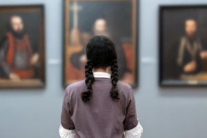 Photo of a woman standing in a museum in front of paintings. Discover how anxiety therapy in Atlanta, GA can help provide you support in managing your anxiety symptoms. Learn here places you can visit in Atlanta, GA to calm your symptoms.