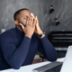 Photo of a man sitting at a desk with his hands covering his face while working. Are you struggling to manage your day to day stress? With therapy for stress in Atlanta, GA you can begin managing your stress symptoms in a healthy way.