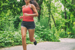 Photo of a woman running on a trail in the forest. Looking for support when it comes to your stress symptoms? Learn new ways to manage stress with therapy for stress in Atlanta, GA.