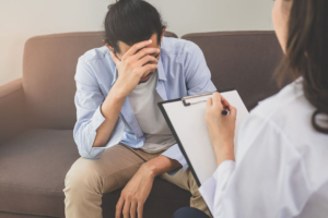 Photo of a young man upset while speaking with a depression therapist. Discover the benefits of depression therapy in Atlanta, GA and how it can help provide you with support in overcoming your symtpoms.