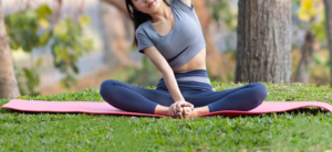 Photo of a woman sitting on the ground practicing yoga. Discover healthy ways to cope with your depression symptoms with depression therapy in Atlanta, GA.