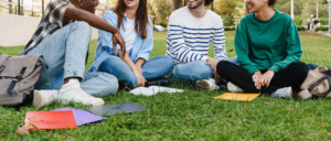 Photo of a group of students studying while smiling and laughing sitting on the grass. Do you struggle with life transitions? Discover ways to navigate the transitions and how anxiety therapy in Atlanta, GA can help support you.
