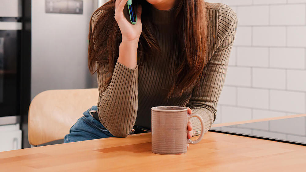 Photo of a woman speaking on a cell phone and smiling. Discover ways to set effective and healthy boundaries from an anxiety therapist in Atlanta, GA.