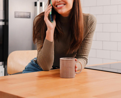 Photo of a woman speaking on a cell phone and smiling. Discover ways to set effective and healthy boundaries from an anxiety therapist in Atlanta, GA.