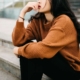 Photo of a woman sitting on stairs holding her hand to her mouth in thought. Learn to effectively challenge your thoughts with the help of anxiety therapy in Atlanta, GA.