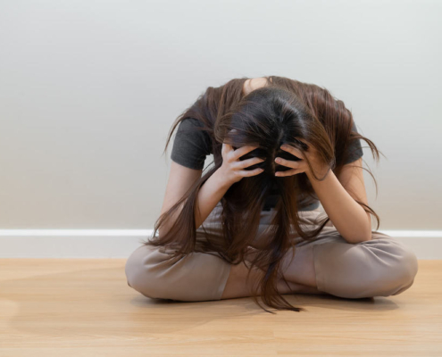 Photo of a woman sitting on the floor with her hands on her head. Do you fear having a depressive episode? Learn how depression therapy in Atlanta, GA can help you overcome the fear.