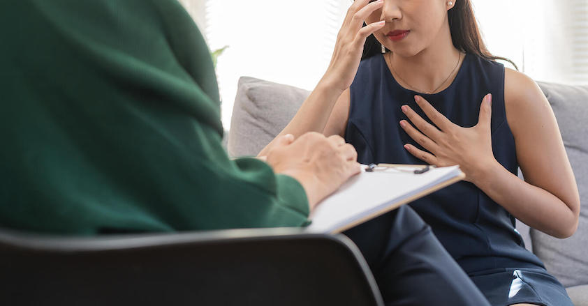 Photo of an upset Asian woman speaking with a depression therapist to help overcome her fear of depressive episodes. Learn to cope with your depression with depression therapy in Atlanta, GA.