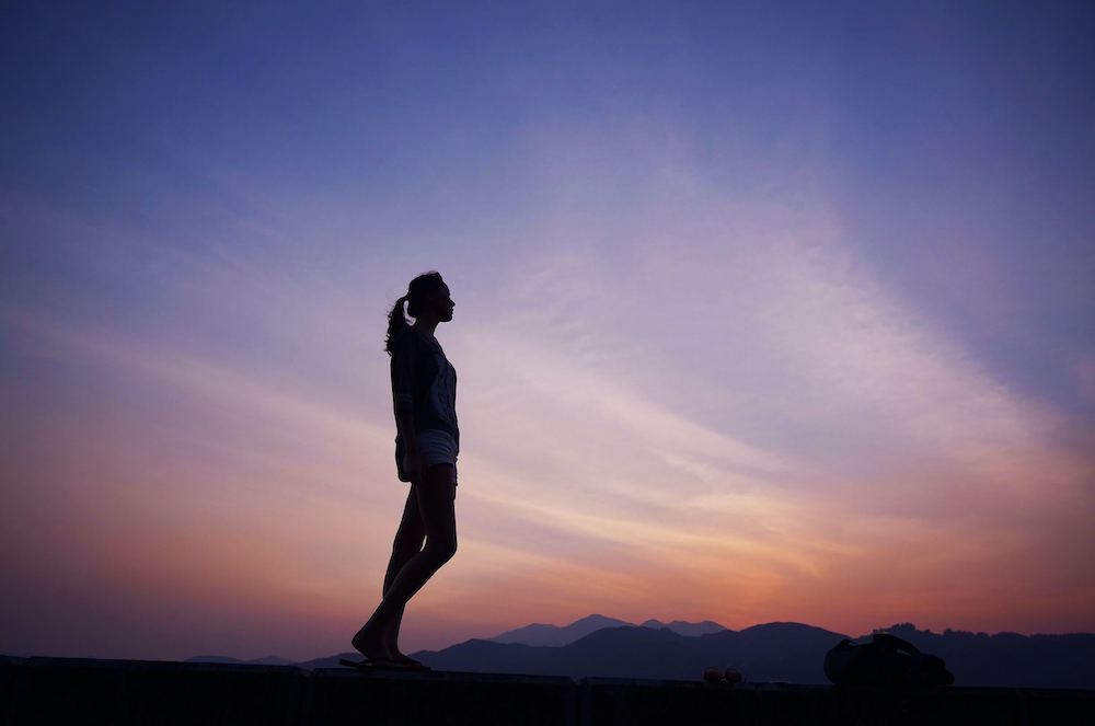 Photo of a woman walking during the sunset on top of a mountain. With the management of anxious thoughts you can begin coping in healthy ways. Find support with anxiety therapy in Atlanta, GA.