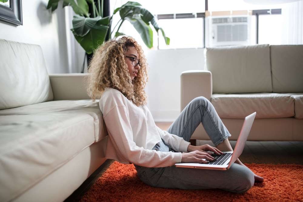 Photo of a woman sitting in her floor working on a laptop. Learn to recognize your anxious thoughts so you can manage them better. Find extra support with anxiety therapy in Atlanta, GA.