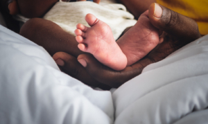 A close up of baby feet being cradled by a parents hands. This could symbolize the bonds cultivated after working with a postpartum therapist in Atlanta, GA. Search for depression therapy in Atlanta, GA to learn more about the help an online depression therapist in Atlanta, GA can offer. 