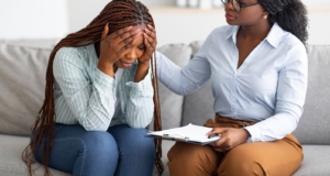 A woman with a clipboard offers a supportive hand for a stressed woman. This could symbolize the support that anxiety therapy in Atlanta, GA can offer for disorders. Search for stress and anxiety counseling in Atlanta, GA or search for anxiety therapist Atlanta, ga today. 