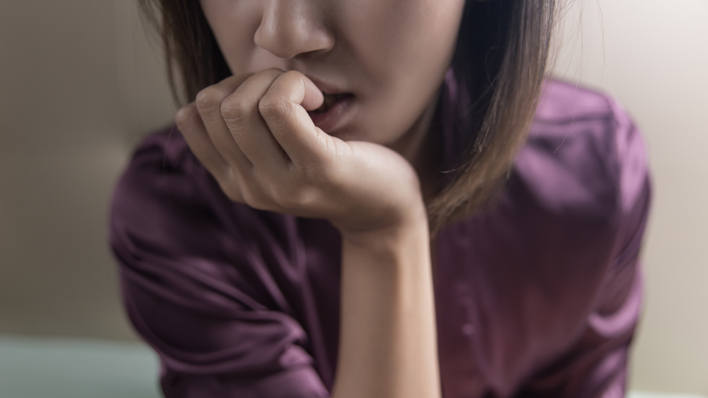 A close up of a stressed woman. Learn more about health anxiety in Atlanta, GA and how online anxiety therapy in Atlanta, GA can offer support with overcoming anxiety. Contact an anxiety therapist in Atlanta, GA for more support today.