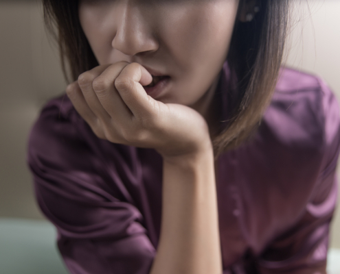 A close up of a stressed woman. Learn more about health anxiety in Atlanta, GA and how online anxiety therapy in Atlanta, GA can offer support with overcoming anxiety. Contact an anxiety therapist in Atlanta, GA for more support today.