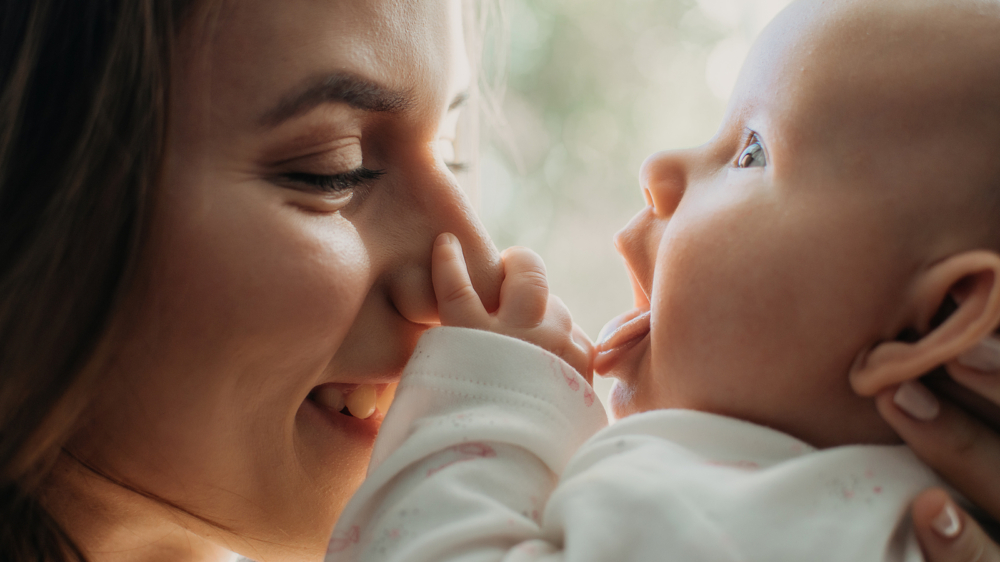 A close up of a mother smiling with her baby. Learn how a postpartum therapist in Atlanta, GA can offer support with bringing baby home. Search for postpartum therapy in Atlanta, GA or birth trauma therapy in Atlanta, GA to learn more today.