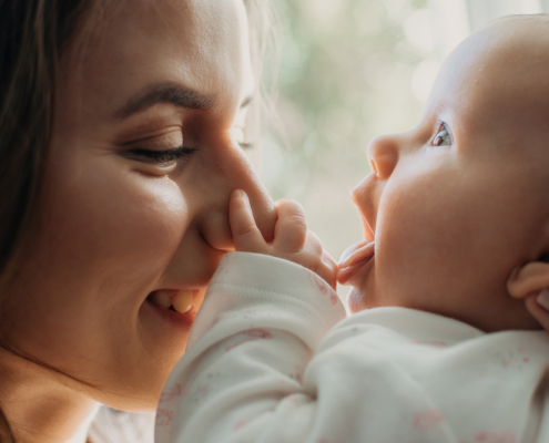 A close up of a mother smiling with her baby. Learn how a postpartum therapist in Atlanta, GA can offer support with bringing baby home. Search for postpartum therapy in Atlanta, GA or birth trauma therapy in Atlanta, GA to learn more today.