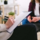A therapist takes notes during a session. If you feel guilt and shame, ADHD therapy in Georgia may be able to help. Start working with a neurodivergent affirming therapist in Atlanta, GA, to develop strategies for improved mental health.