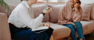 A smiling woman talks with her ADHD therapist in Atlanta, GA during a warm and supportive session. ADHD therapy Atlanta, GA helps individuals develop strategies for success through personalized ADHD treatment in Atlanta, GA. 