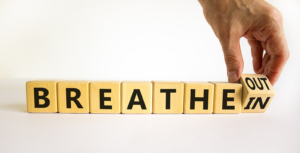 Wooden blocks spelling breathe in and breathe out symbolize coping strategies offered through postpartum therapy in Atlanta, GA, postpartum counseling Atlanta, anxiety therapy in Atlanta, GA, and postpartum anxiety treatment Atlanta. 