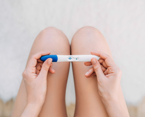 A woman holds a positive pregnancy test, reflecting mixed emotions of hope and fear while seeking postpartum therapy in Atlanta, GA, postpartum counseling Atlanta, postpartum anxiety treatment Atlanta, and Alpharetta postpartum anxiety treatment.