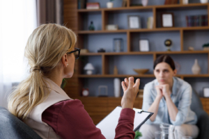 A focused therapy session between a woman and a clinician, reflecting the value of postpartum anxiety treatment in Atlanta and working with a postpartum therapist in Atlanta, GA for lasting support. 