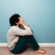 A distressed man sits on the floor covering his face, symbolizing emotional pain and overwhelm. A trauma therapist in Atlanta, GA can provide support through trauma therapy in Atlanta, GA and help address related struggles often seen in depression therapy in Atlanta, GA.