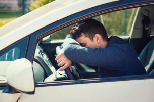 Exhausted driver resting his head on the steering wheel, a common scene for commuters dealing with panic or social anxiety in Atlanta, GA. Consider anxiety therapy Atlanta GA with an experienced anxiety therapist in Atlanta, GA. 