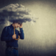 A man stands under a storm cloud, holding an umbrella as rain pours—capturing the heaviness of loss and worry. Support like grief counseling in atlanta, ga with a compassionate grief therapist in atlanta, ga can also include therapy for anxiety in atlanta, ga to ease the pressure.