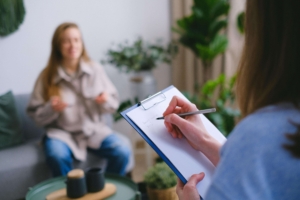 Therapist taking notes while a client shares in a calm office. Ideal for pages about anxiety therapy in Atlanta, GA, options for online anxiety therapy in Atlanta, GA, and meeting an anxiety therapist in Atlanta, GA for ongoing care. 